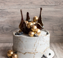 Тортик с золотой каймой, карамельной вазой, голубикой и шоколадными шарами